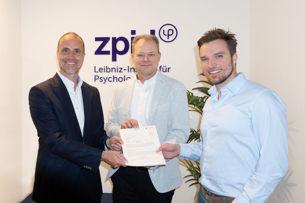 Clemens Hoch, Minister für Wissenschaft, Weiterbildung und Gesundheit in Rheinland-Pfalz übergibt den Förderbescheid an Prof. Dr. Kai Sassenberg und Jun.-Prof. Dr. Frederic Hopp (v.l.n.r.), Projektleiter Psy-AI im Leibniz-Institut für Psychologie (ZPID) in Trier. Foto: Bettina Leuchtenberg